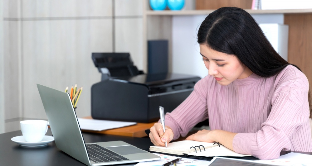 An image showing a student writing a college admissions essay with thoughtful expression.