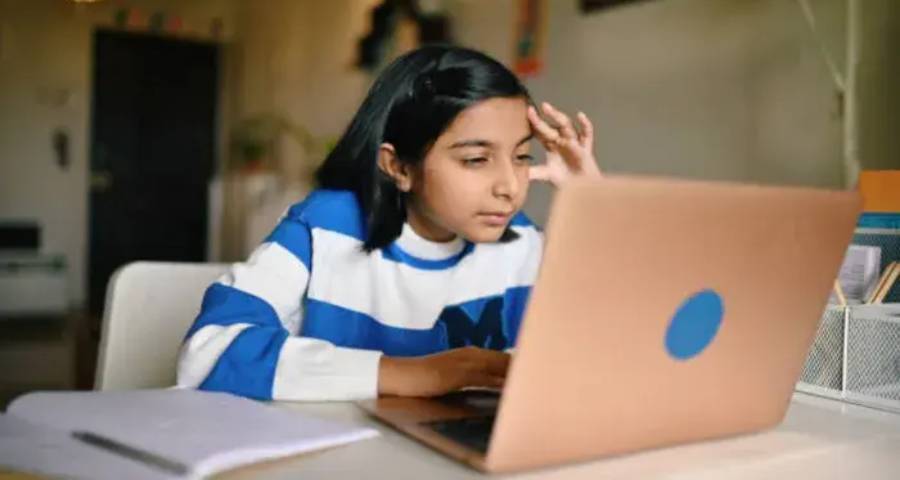 Student using AI tool ethically on laptop for research and college application preparation 