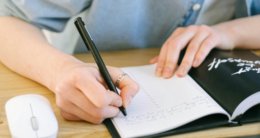 Student writing research notes in a notebook — the deep independent research culture that defines the undergraduate experience at Princeton and the Ivy League