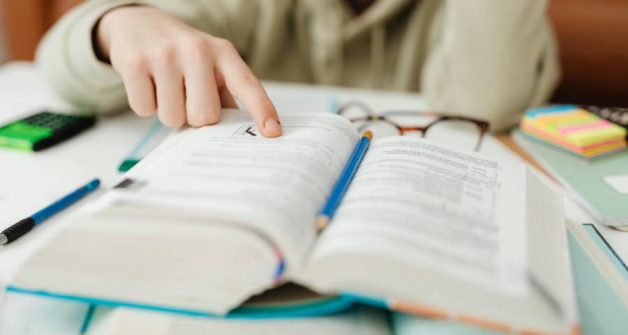 Student surrounded by study papers and books late at night — the overwhelming workload that triggers college application anxiety in Indian Class 12 students