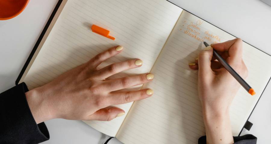 Student journaling and reflecting at desk — the first step to writing a powerful Ivy League college essay