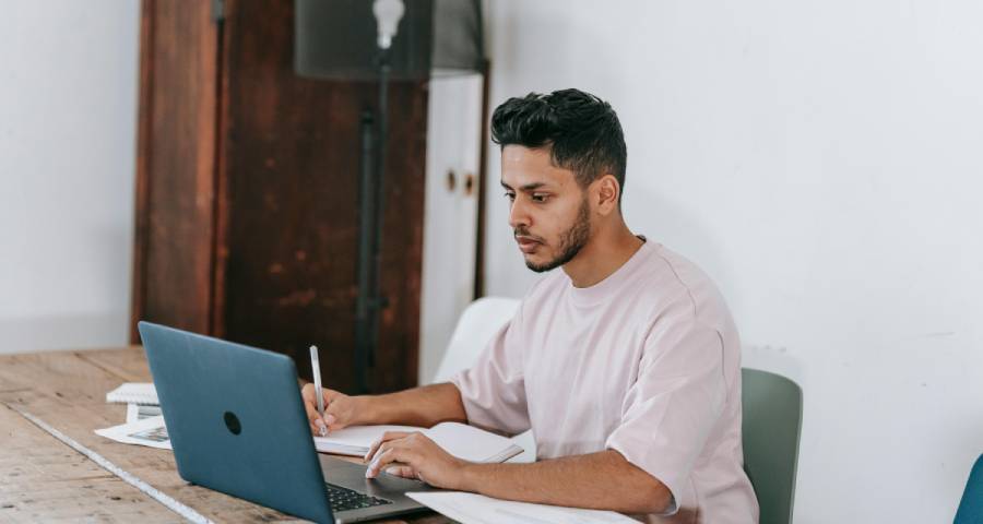 Focused student writing at desk late at night — crafting an authentic personal essay for Ivy League application