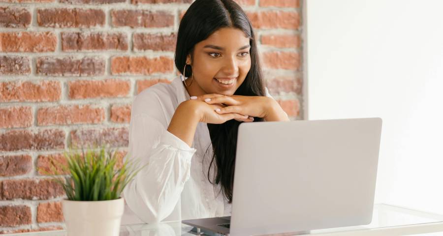 Young woman using laptop to manage social media and build her personal brand online 